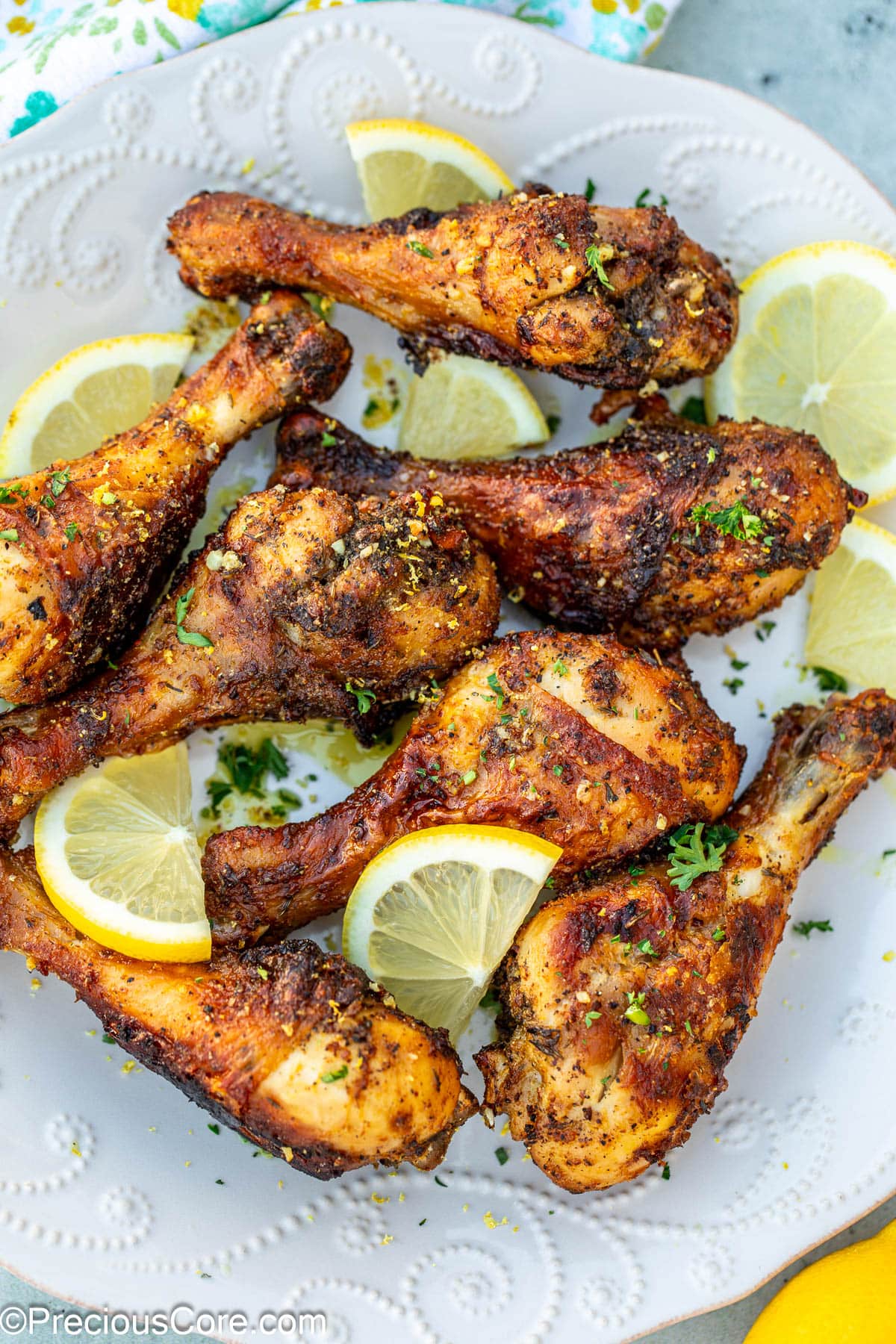 Cooked lemon pepper drumsticks on a white plate.