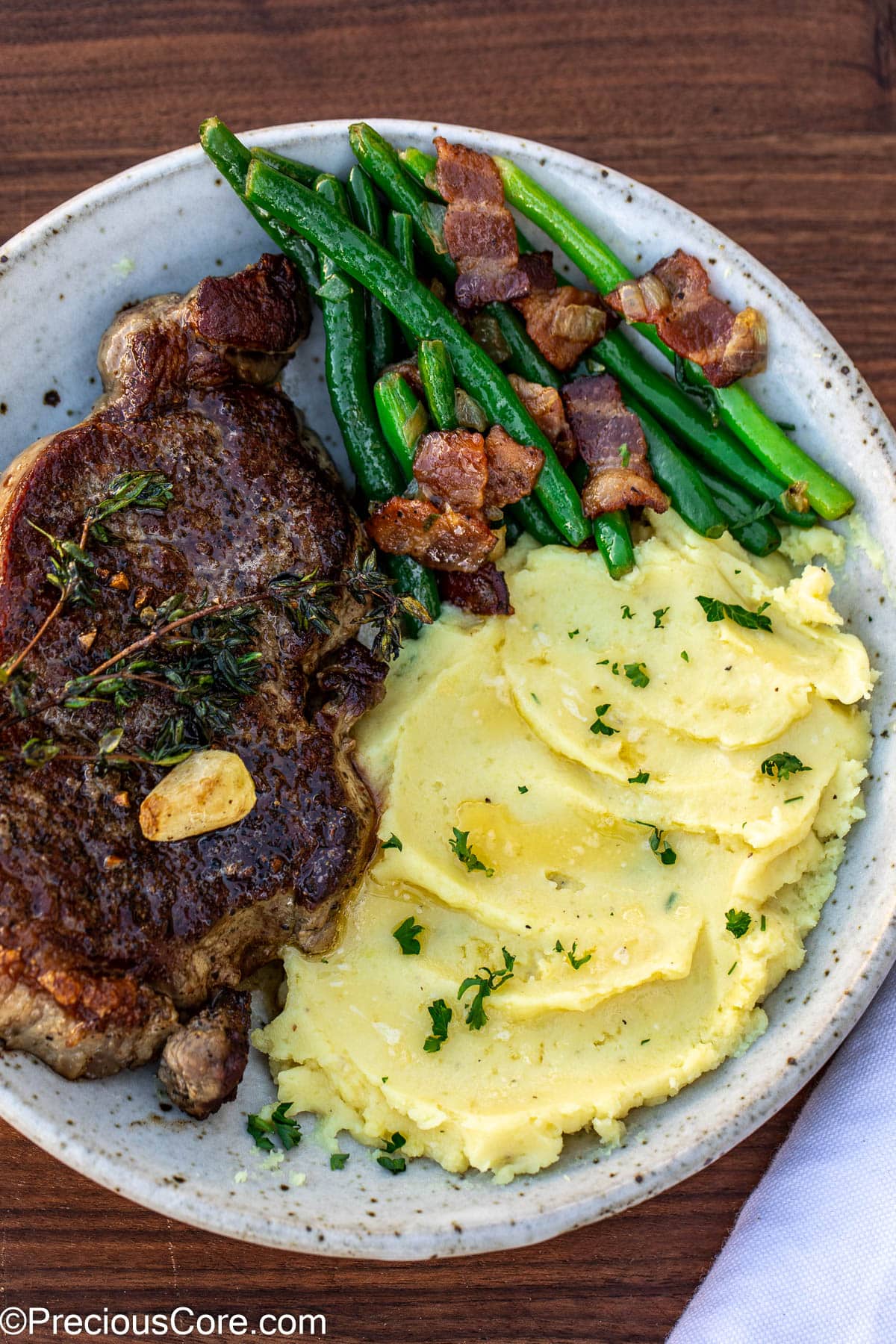 Bacon green beans served with steak and mashed potatoes.